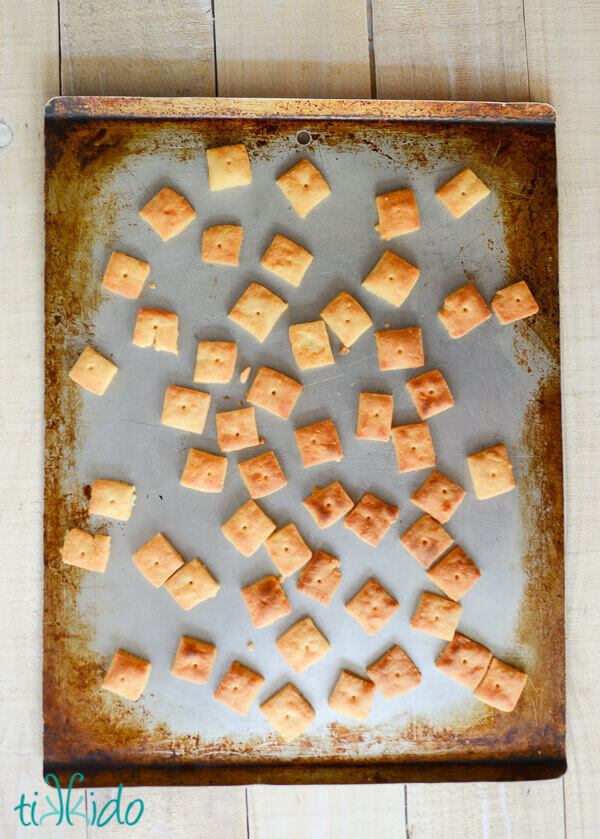 Homemade cheese crackers baked on a cookie sheet.