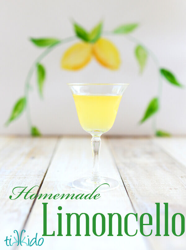 Small glass of limoncello with a painted lemon watercolor backdrop behind.