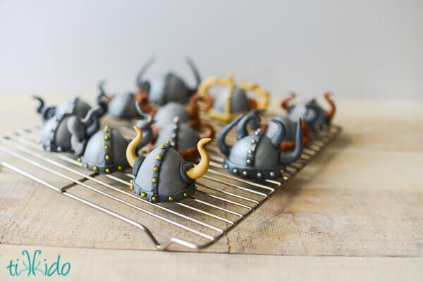 Viking helmet cupcake toppers on a drying rack.