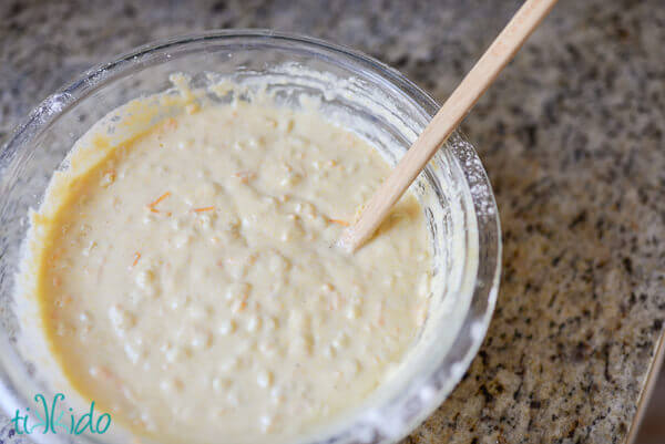 Savory cornmeal cheddar pancake batter in a clear pyrex bowl.