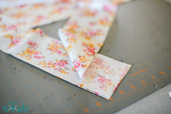 Strips of fabric ribbon being sewn together to create longer fabric ribbon.