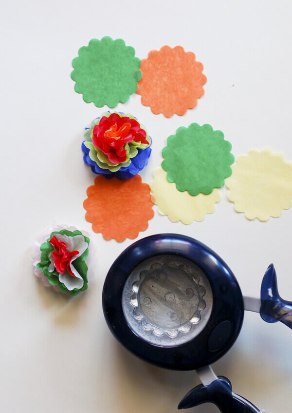 Scalloped circle paper punch and tissue paper cut into circles, some gathered into miniature Mexican tissue paper flowers.