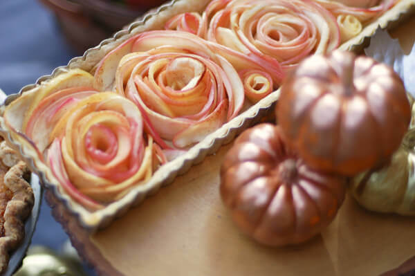 Rose Apple Pie in a rectangular pie tin, next to miniature pumpkins.