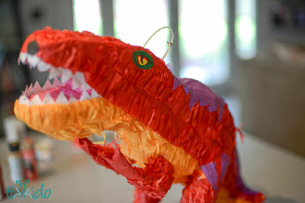 Store bought dinosaur pinata ready to be transformed into an easy DIY Dragon piñata.