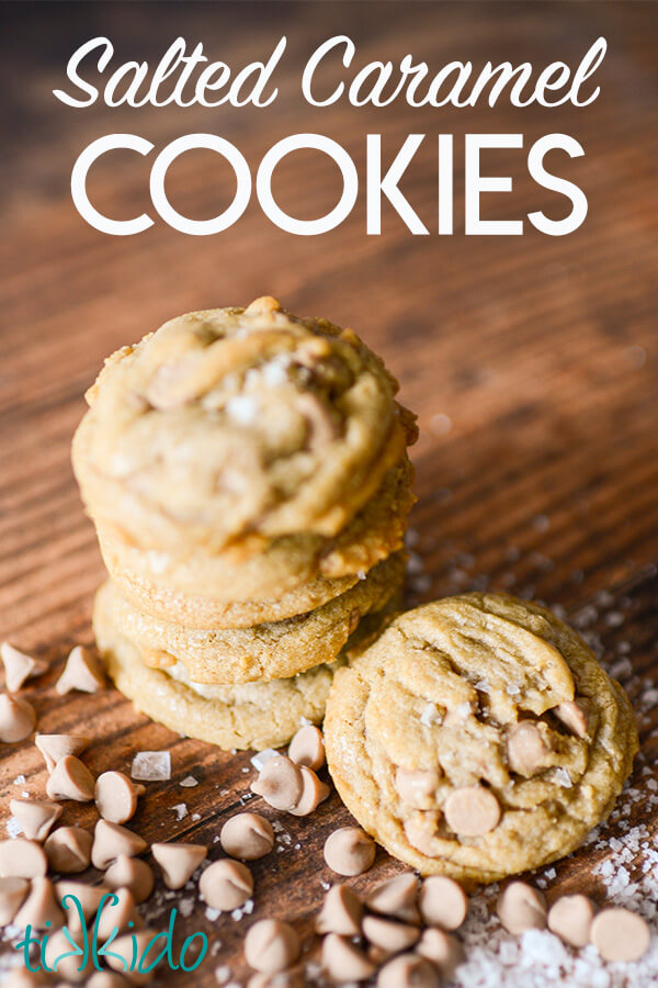 Salted Caramel Cookies stack of salted caramel cookies on a wooden surface, surrounded by salted caramel baking chips and flakes of sea salt. Text overlay reads "Salted Caramel Cookies."