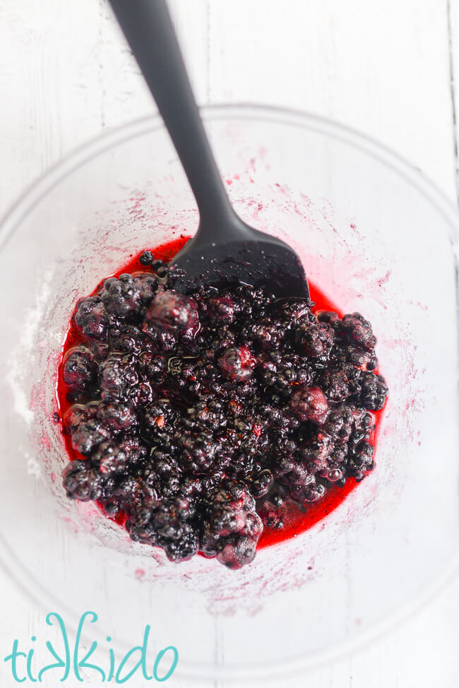 Macerated blackberries in a glass bowl for making Blackberry Gin.