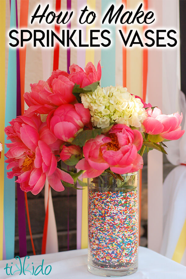 Sprinkles Party Decor A vase filled with rainbow sprinkles and a pink and white flower arrangement, in front of a colorful ribbon backdrop, with text overlay reading "How to Make Sprinkles Vases."