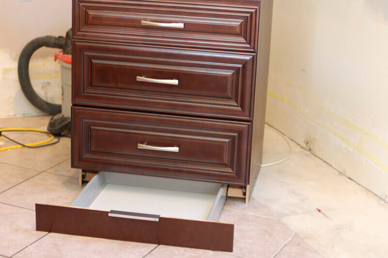 Kitchen cabinets with hidden toe kick drawer